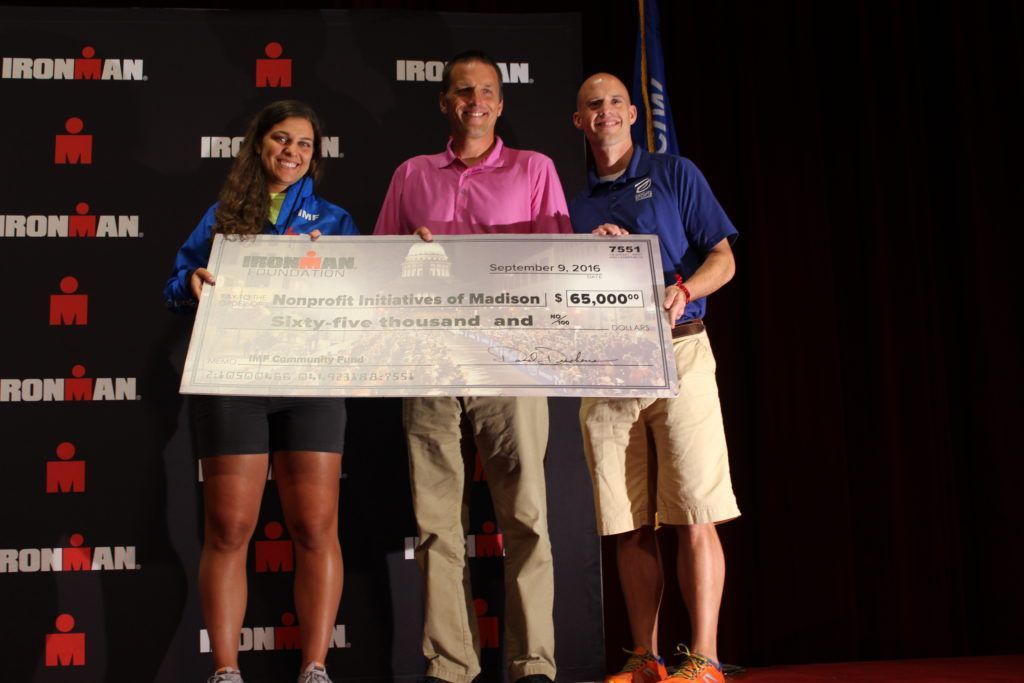 Star Intern, Julie Bengis, presents a grant check to the Madison Area Sports Commission at the IRONMAN Wisconsin Welcome Banquet.