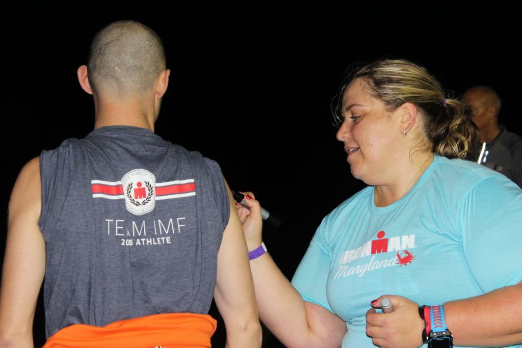 TEAM IMF Athlete Robert Hicks gets body marked in transition. He’s ready to tackle his IRONMAN race!