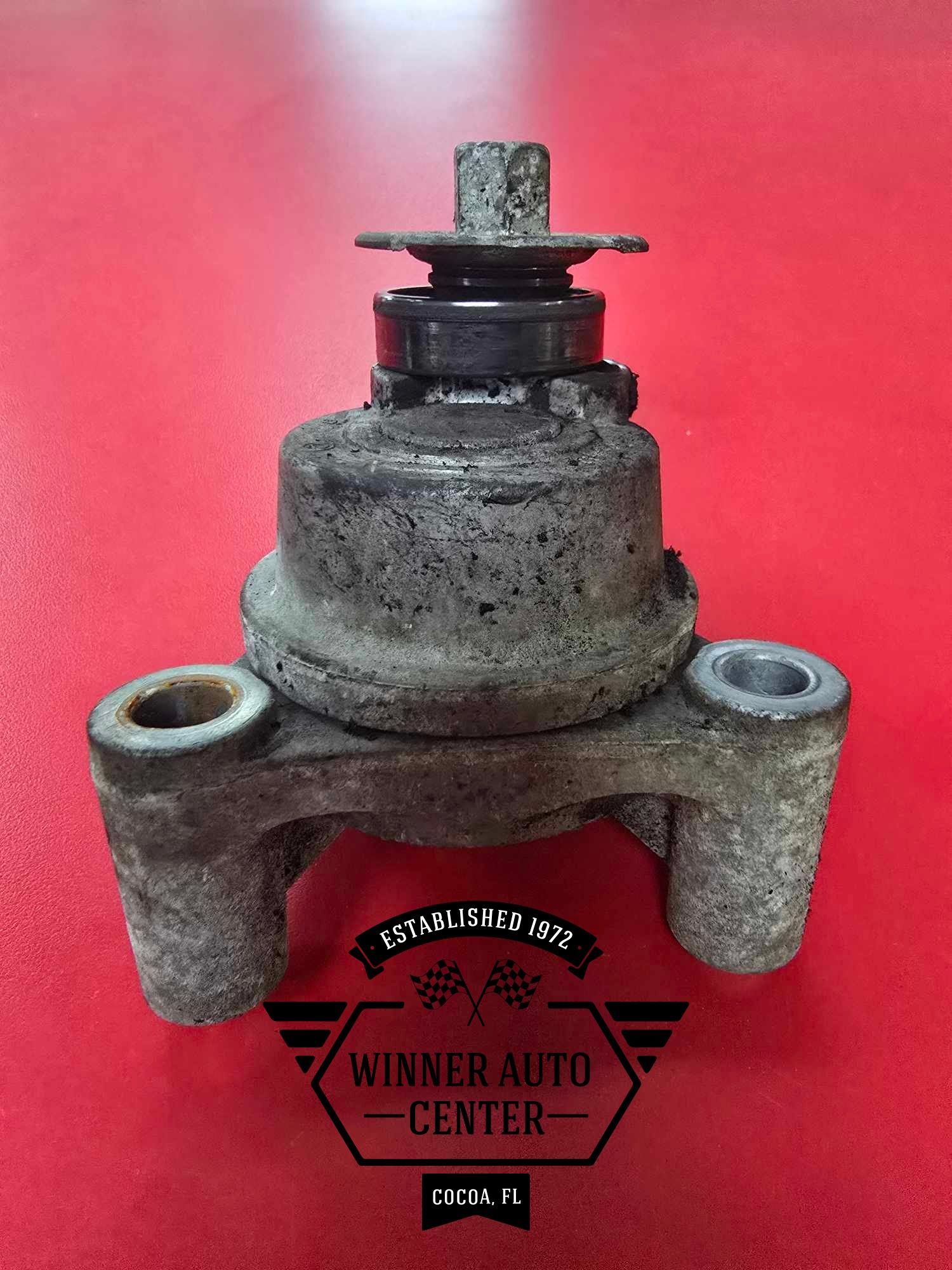 A worn engine mount with two holes at the bottom and a bolt on top | Winner Auto Center