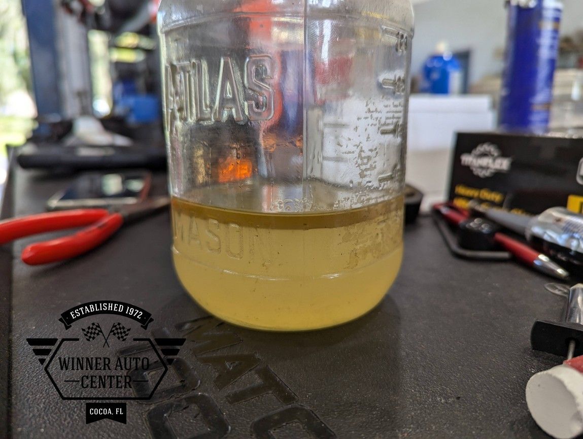 A mason jar containing a yellow liquid | Winner Auto Center