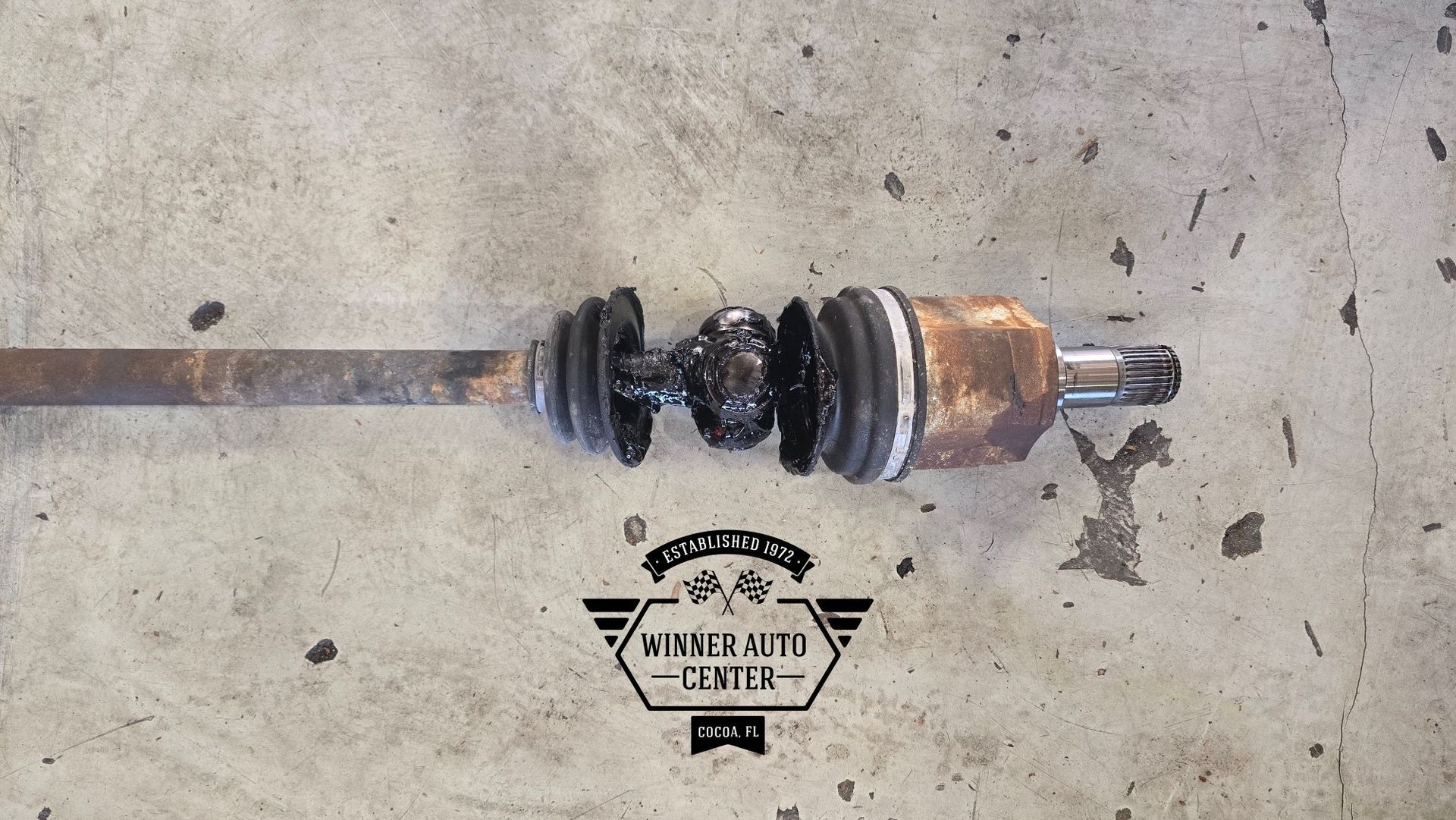 A broken car axle covered in black grease | Winner Auto Center