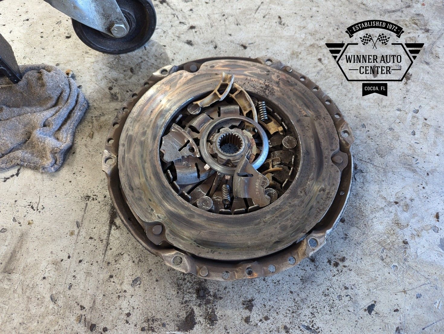 A worn clutch disc on a concrete surface | Winner Auto Center