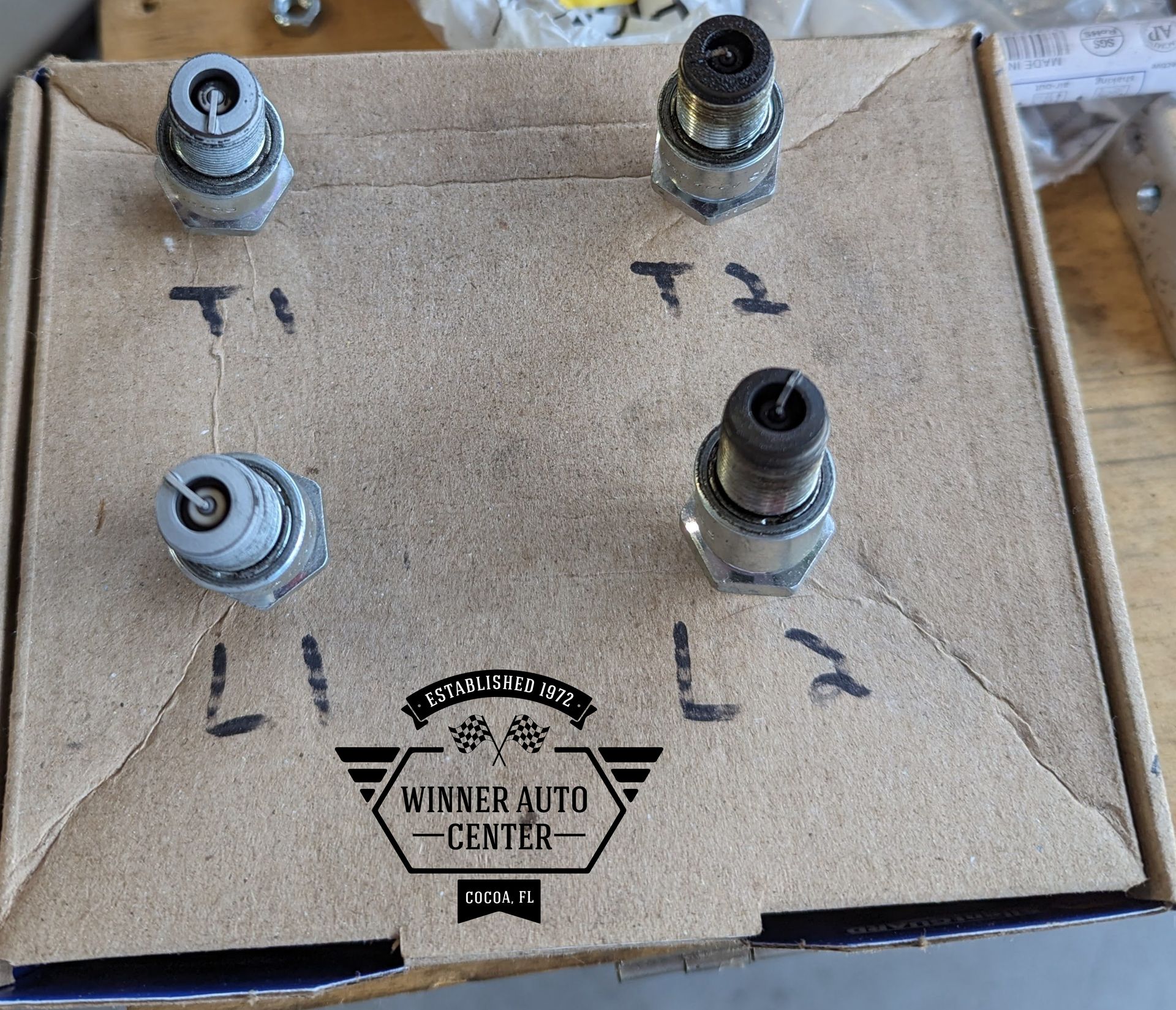Four spark plugs labeled
