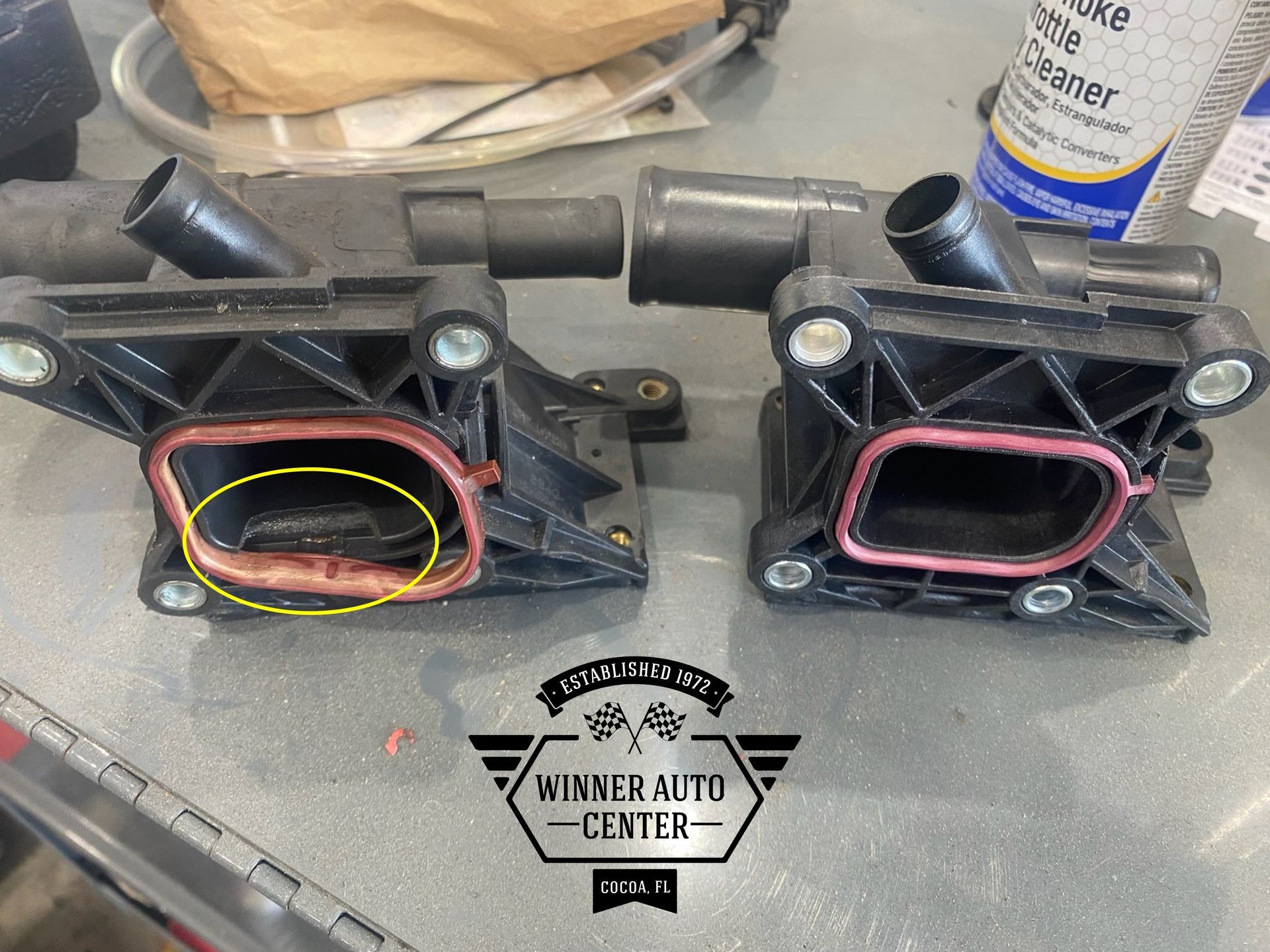 Two black engine coolant outlet housings | Winner Auto Center