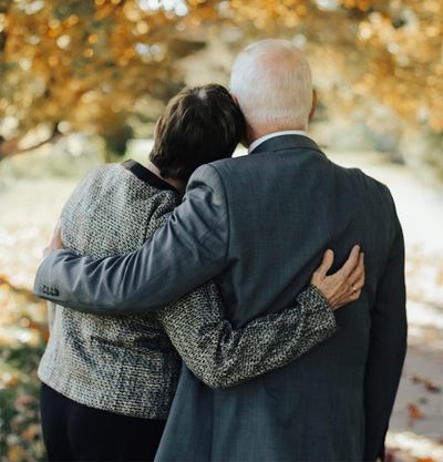 Couple embrace after participating in virtual funeral or online memorial service.