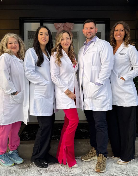 Group of people in red tops pose on steps of a building. Group of people in red tops pose on steps of a building.