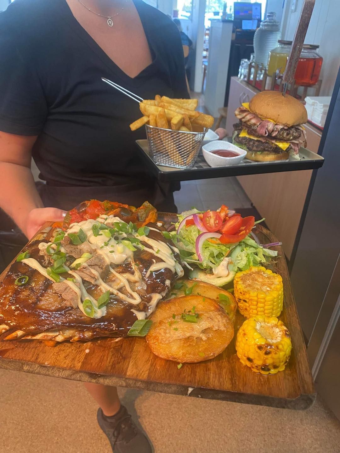 Waitress holding plates of food — Hart & Soul Bar and Grill in Toukley, NSW