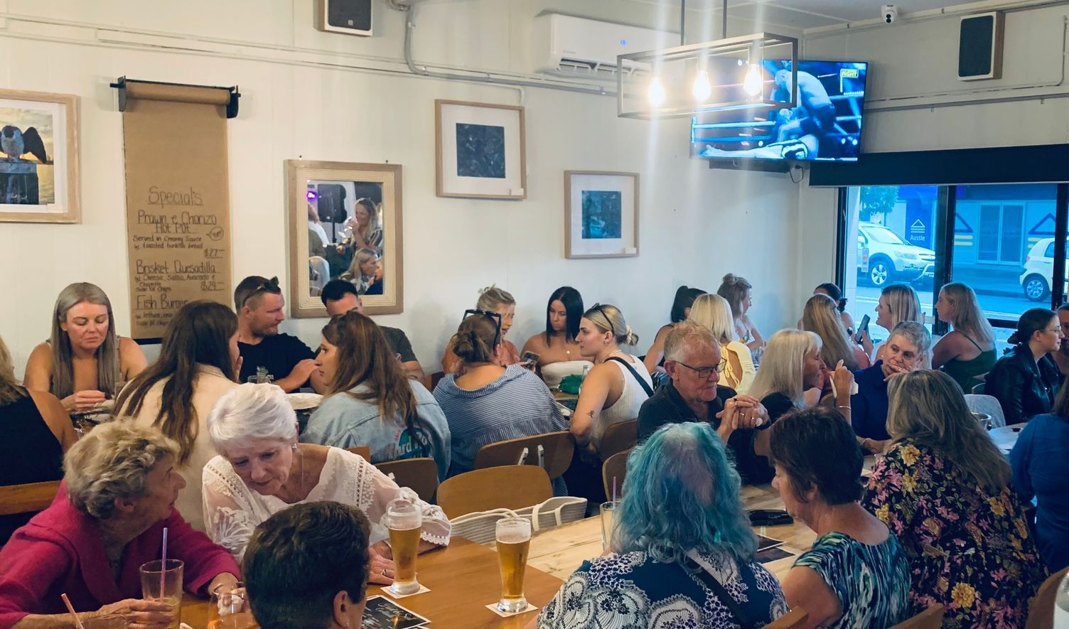 A group of people are sitting at tables in a restaurant.
