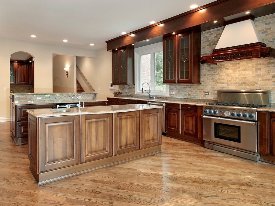 A large kitchen with stainless steel appliances and wooden cabinets.