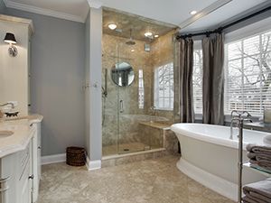 A bathroom with a tub , sink , shower and window.