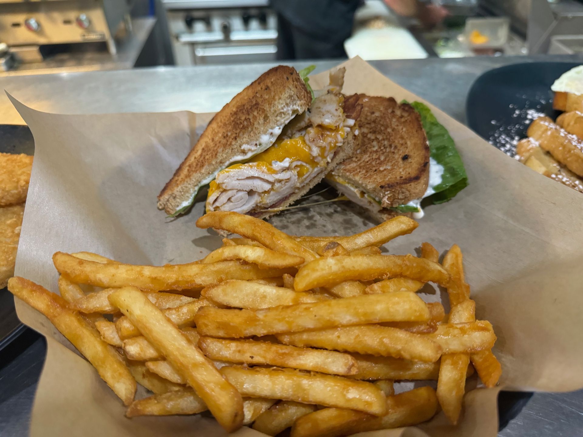 A grilled cheese sandwich and french fries are on a table.