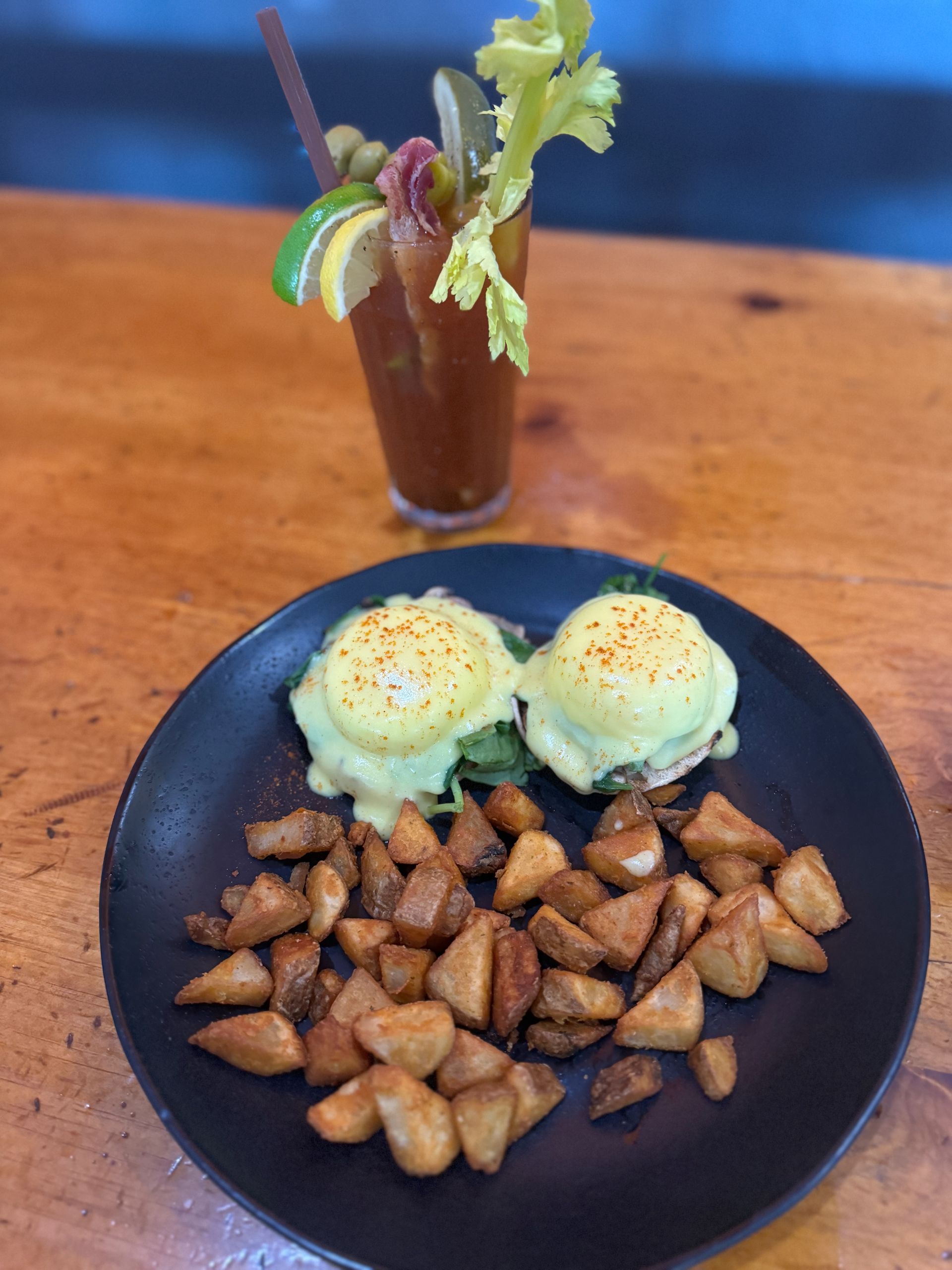 two Benedict eggs with home fries on a plate