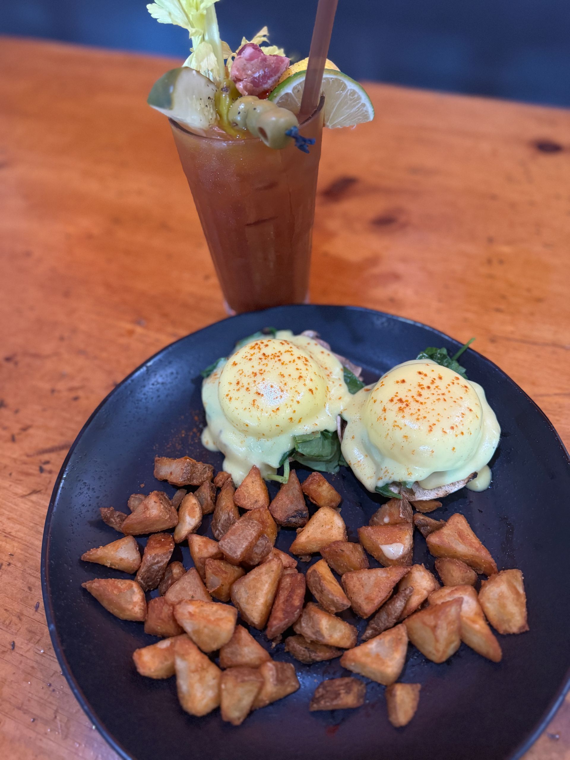 two Benedict eggs with home fries on a plate