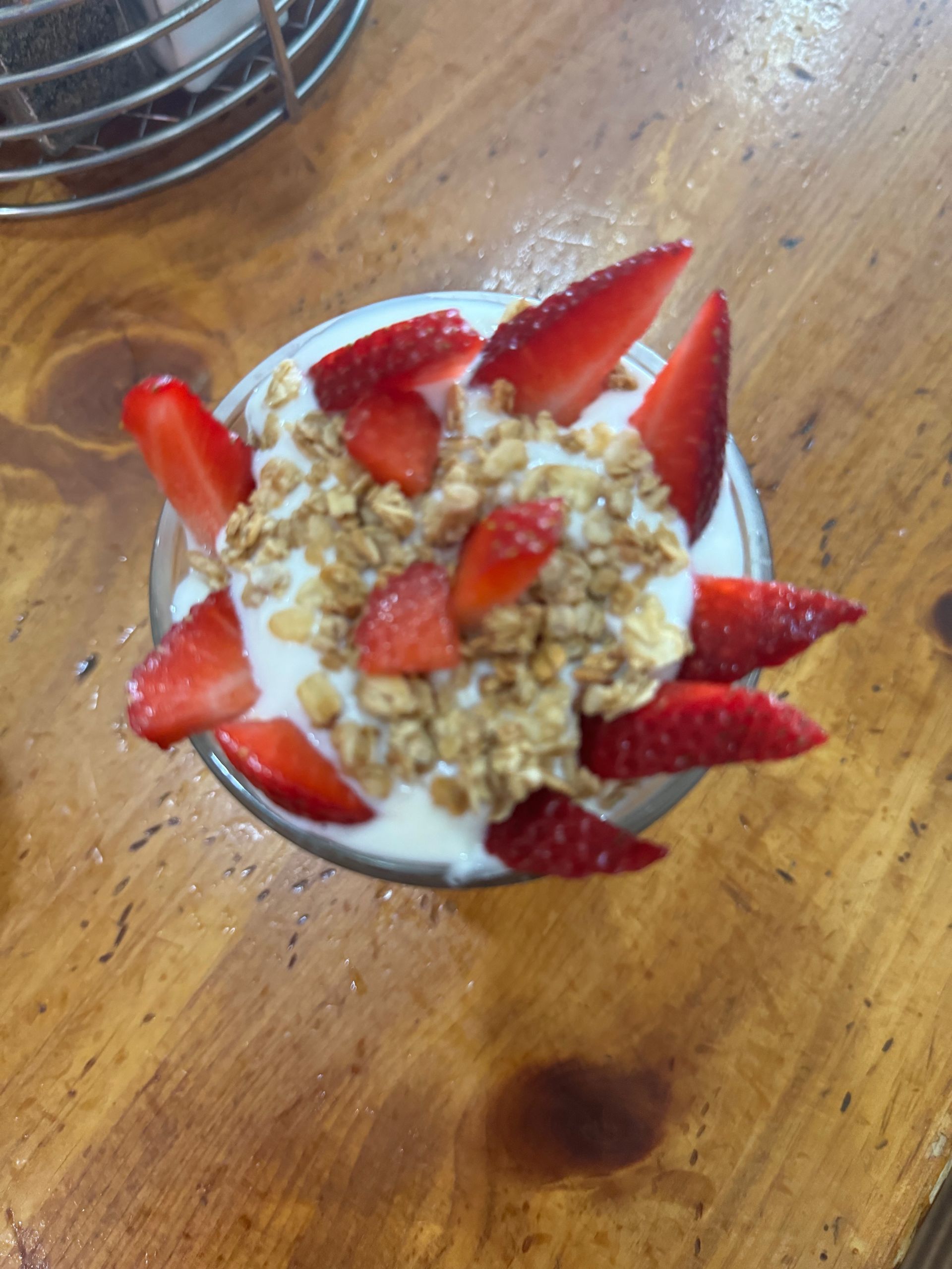 A bowl of yogurt with strawberries and granola on top