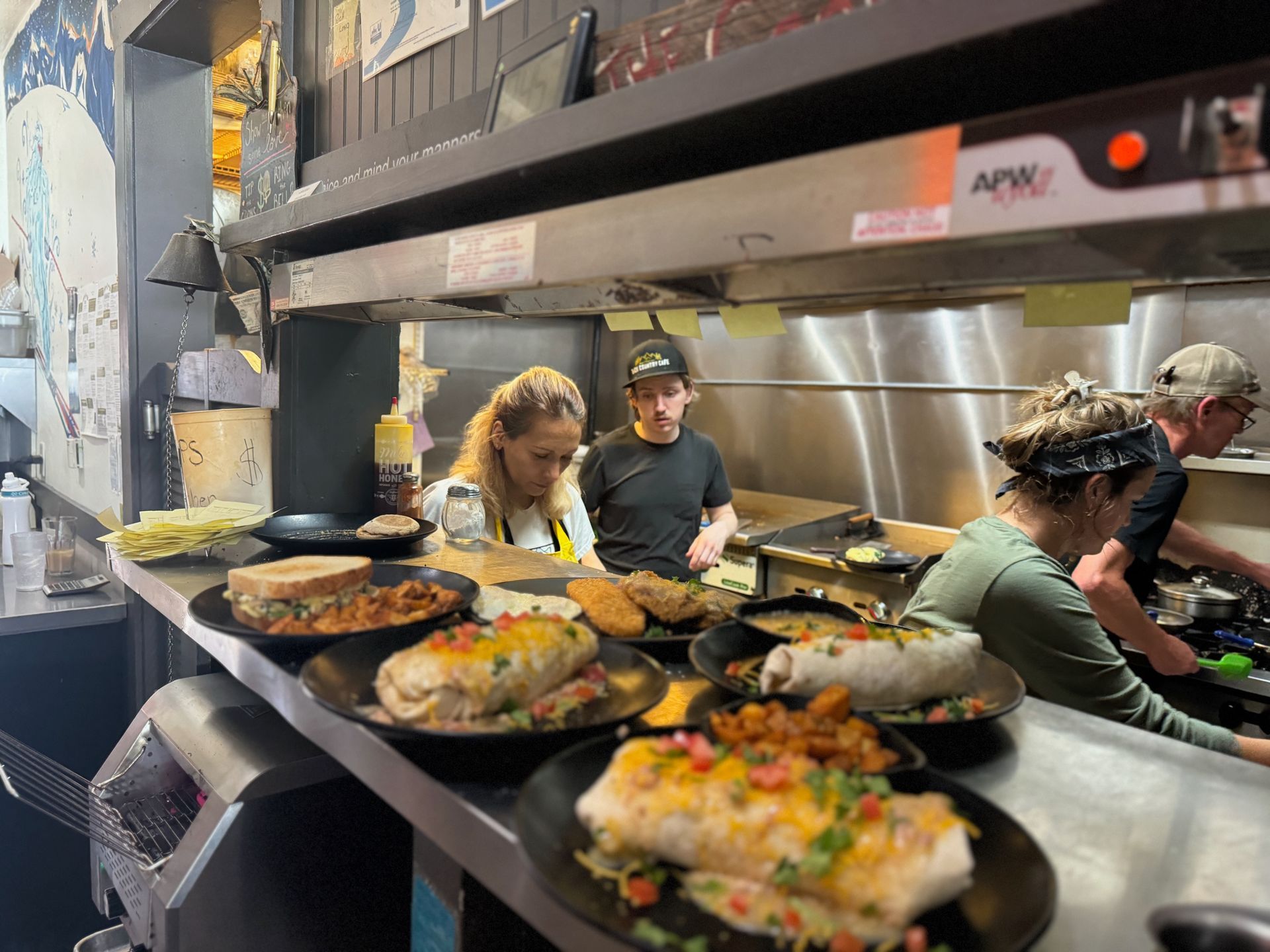 A group of people are preparing food in a restaurant kitchen.