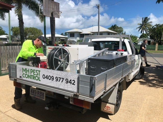 Pest Control Technician Next to Work Vehicle — Residential & Commercial Pest Control in Sarina, QLD
