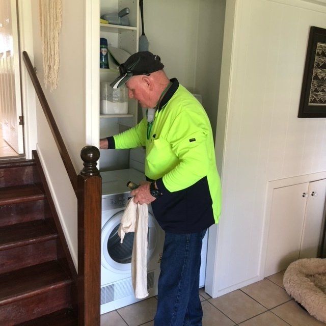 Pest Control Technician Spraying Indoors Laundry - Residential & Commercial Pest Control in Mackay, QLD