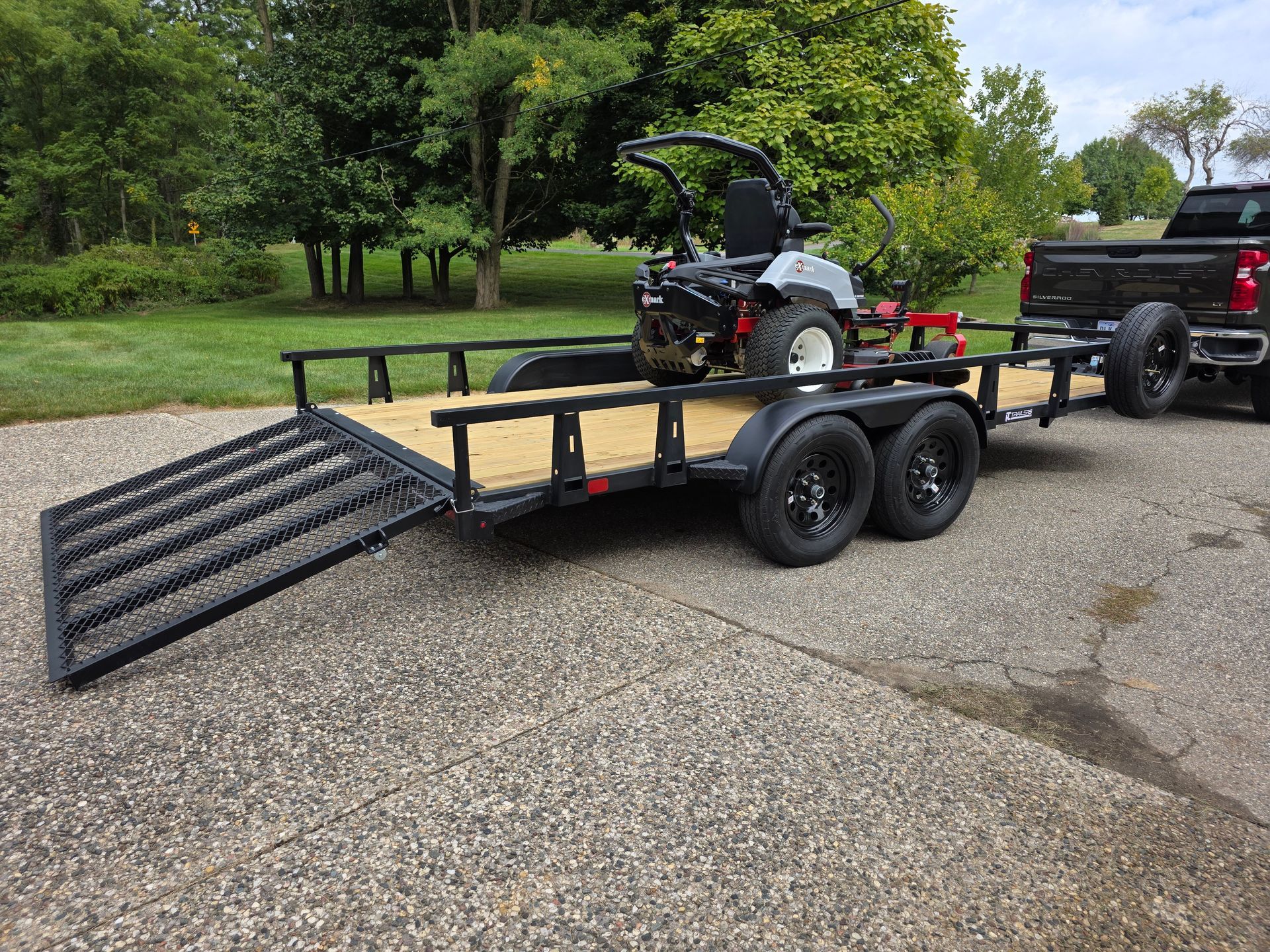 lawn mower loaded on tandem utility trailer