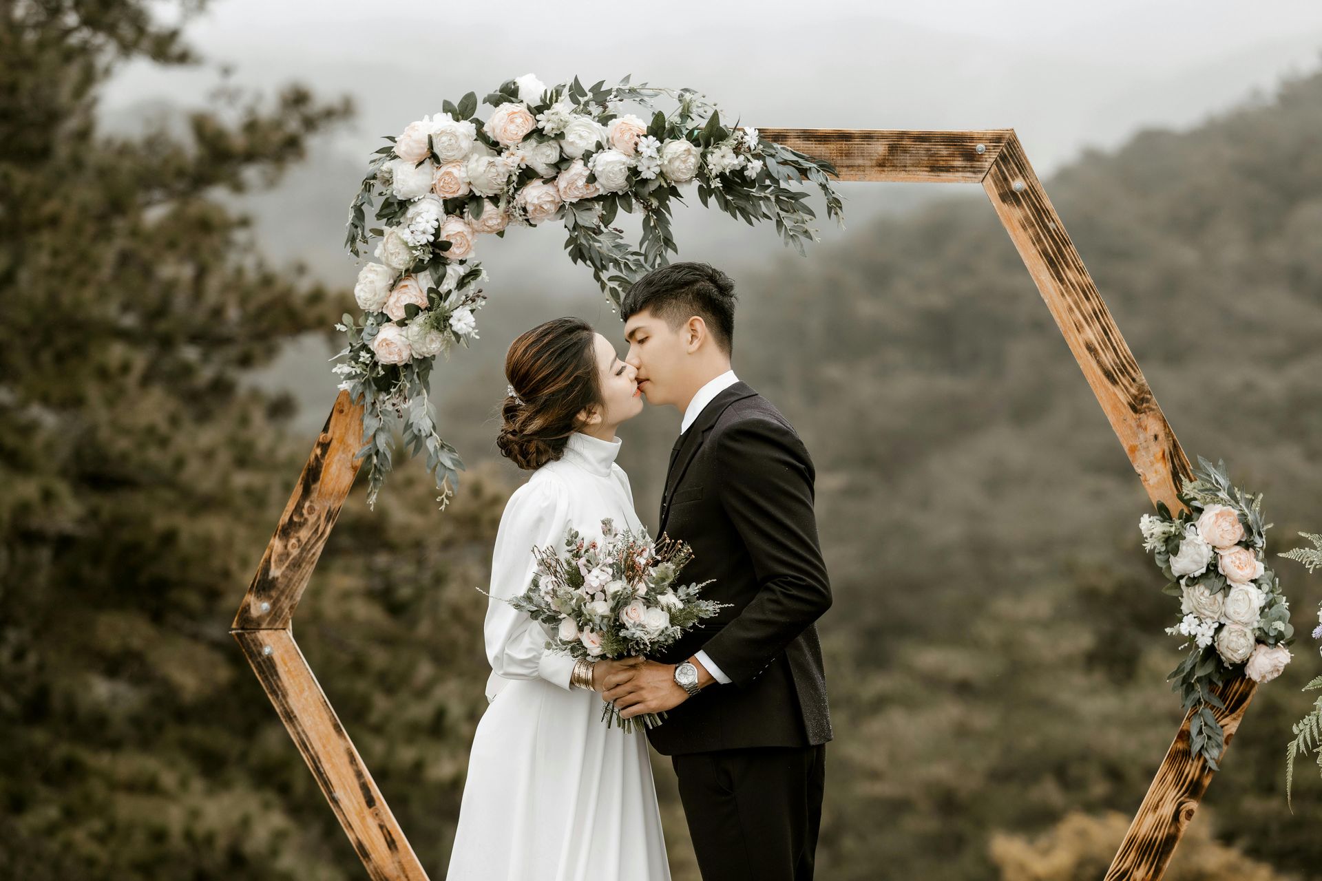 Bride and groom sharing a romantic kiss after their wedding ceremony.