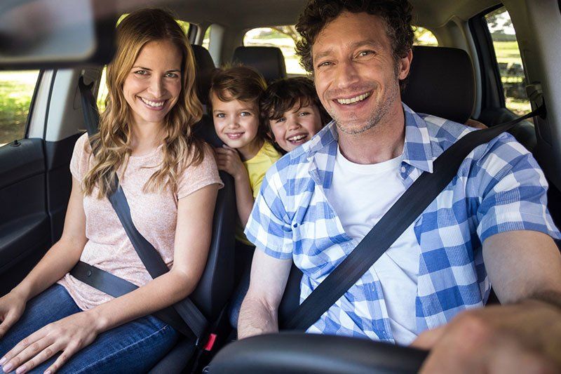 Smiling Family Sitting in The Car — Greenacres FL — Roy-Roth Agency