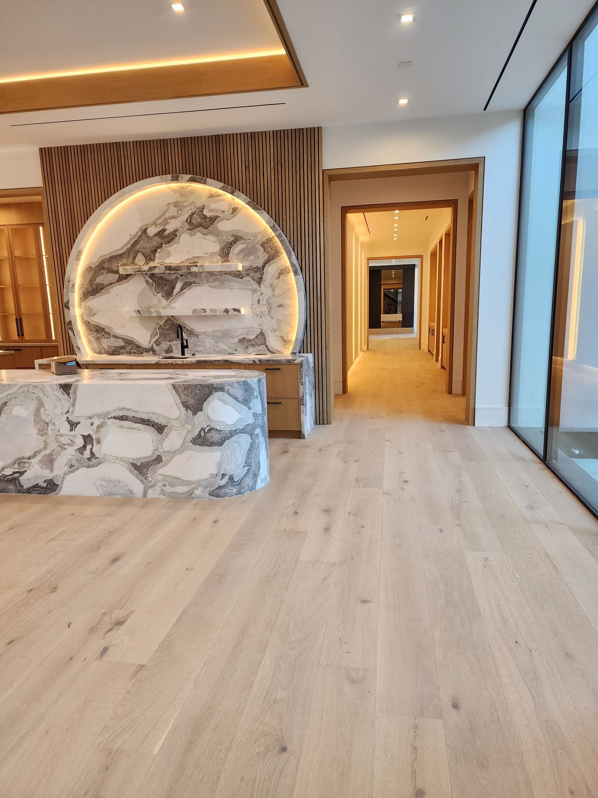 Reception area with marble counter, wood paneling, and a hallway leading to interior.