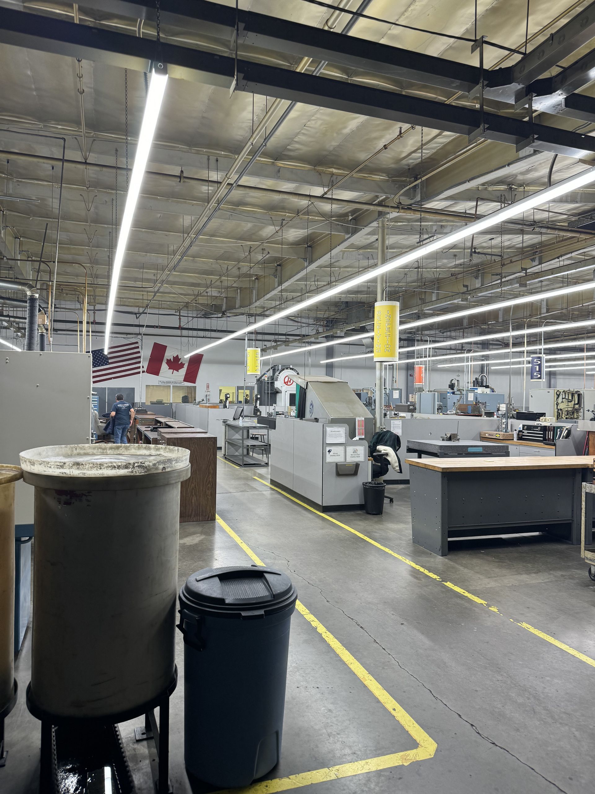 A large warehouse with a lot of machinery and trash cans