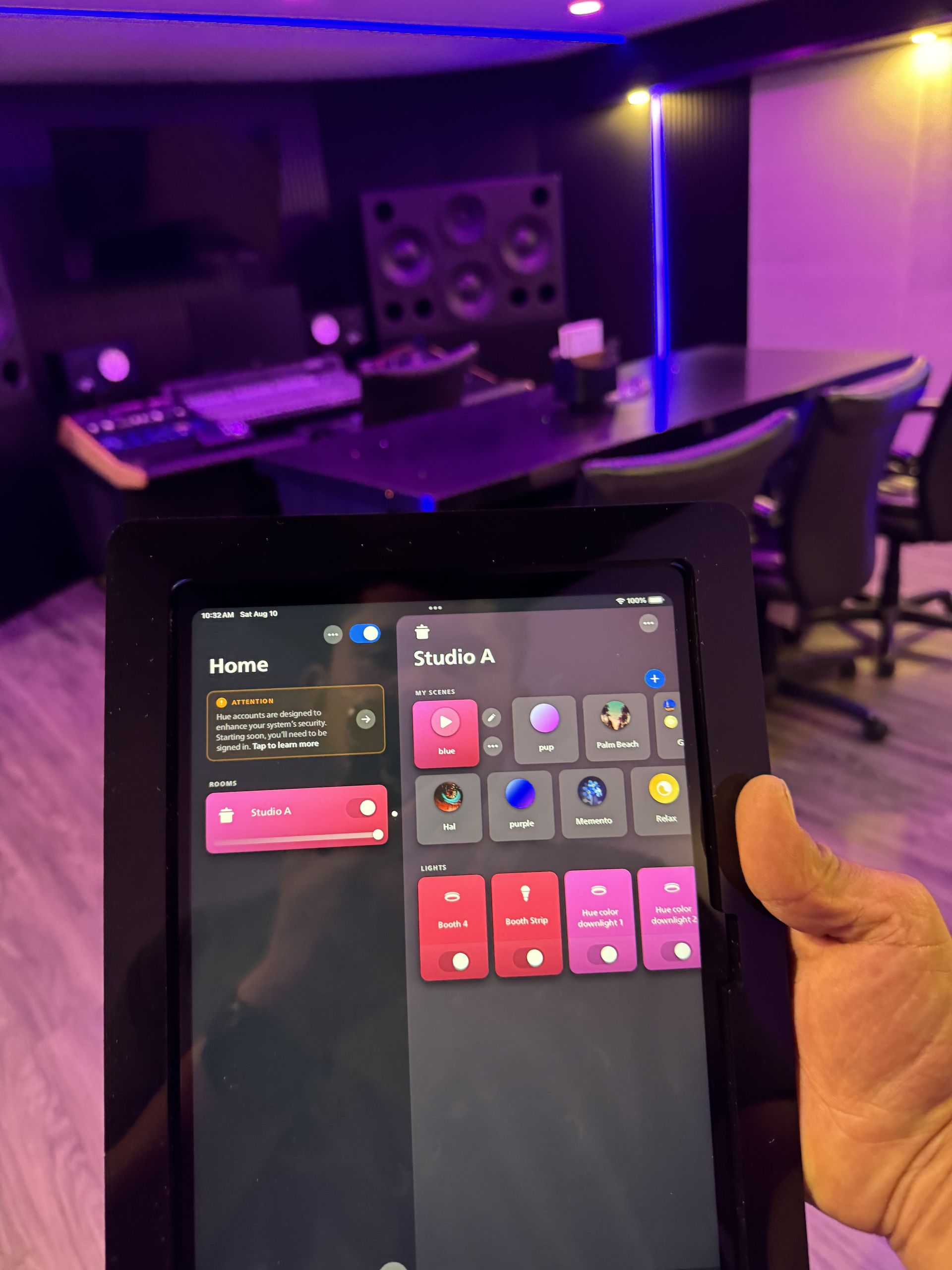 A person is holding a tablet in front of a recording studio.