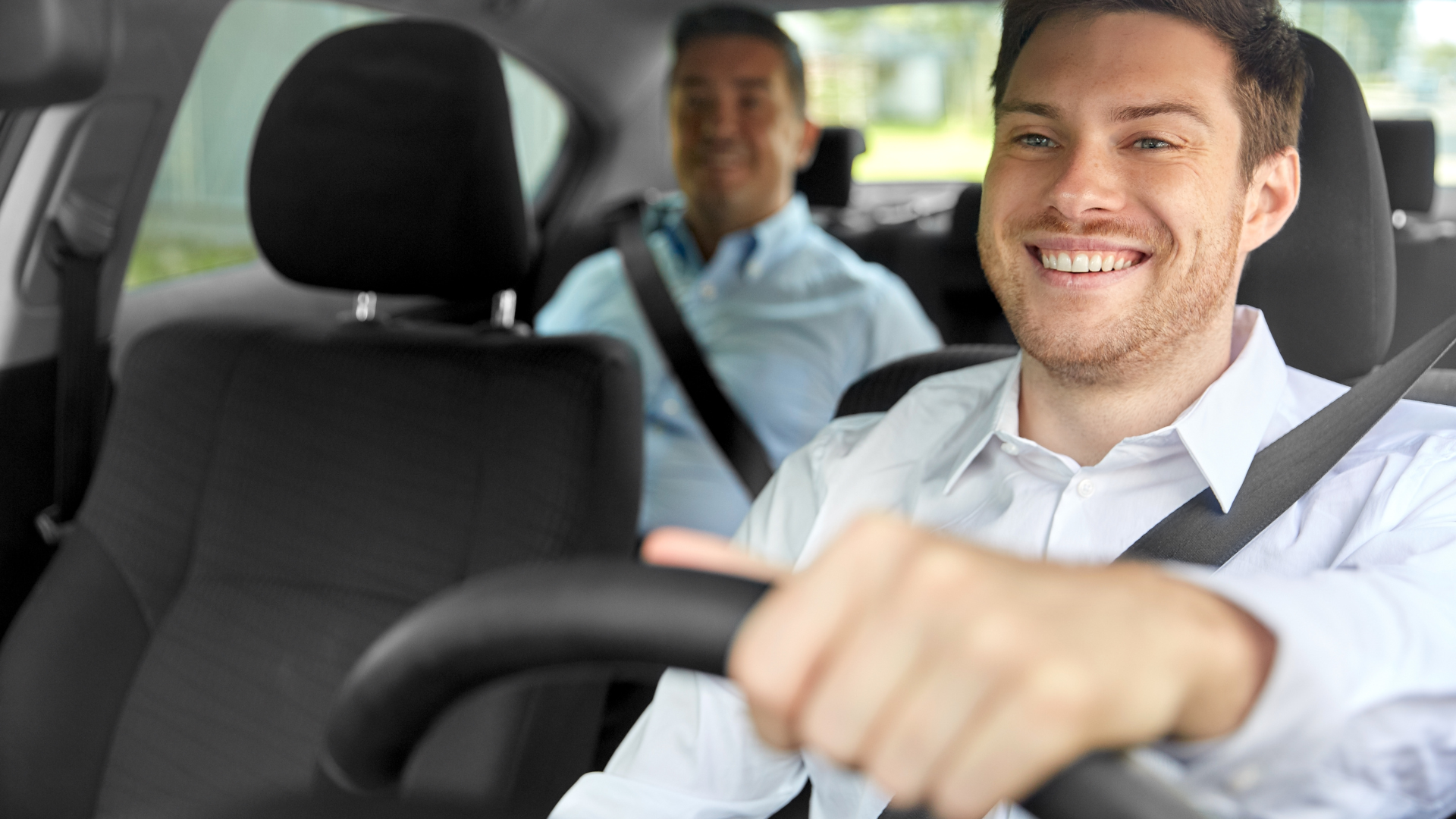 Um homem está dirigindo um carro com outros dois homens no banco de trás.