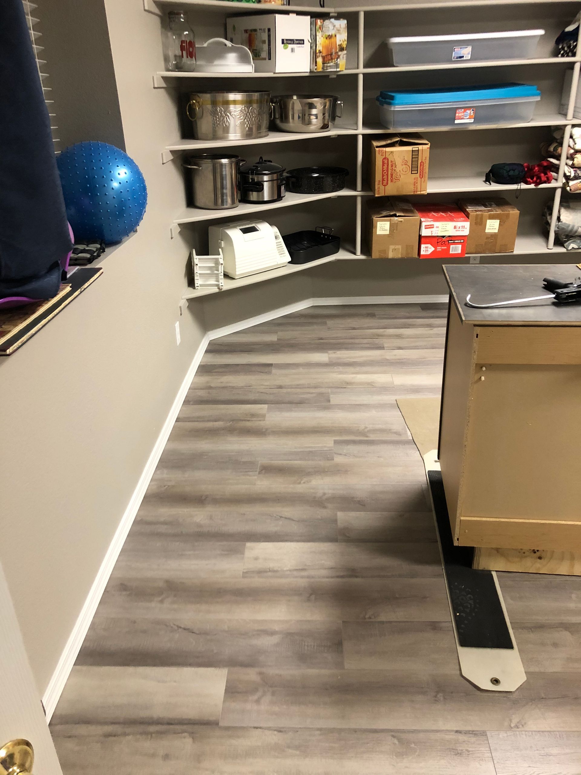 A room with a lot of shelves and boxes on the floor.