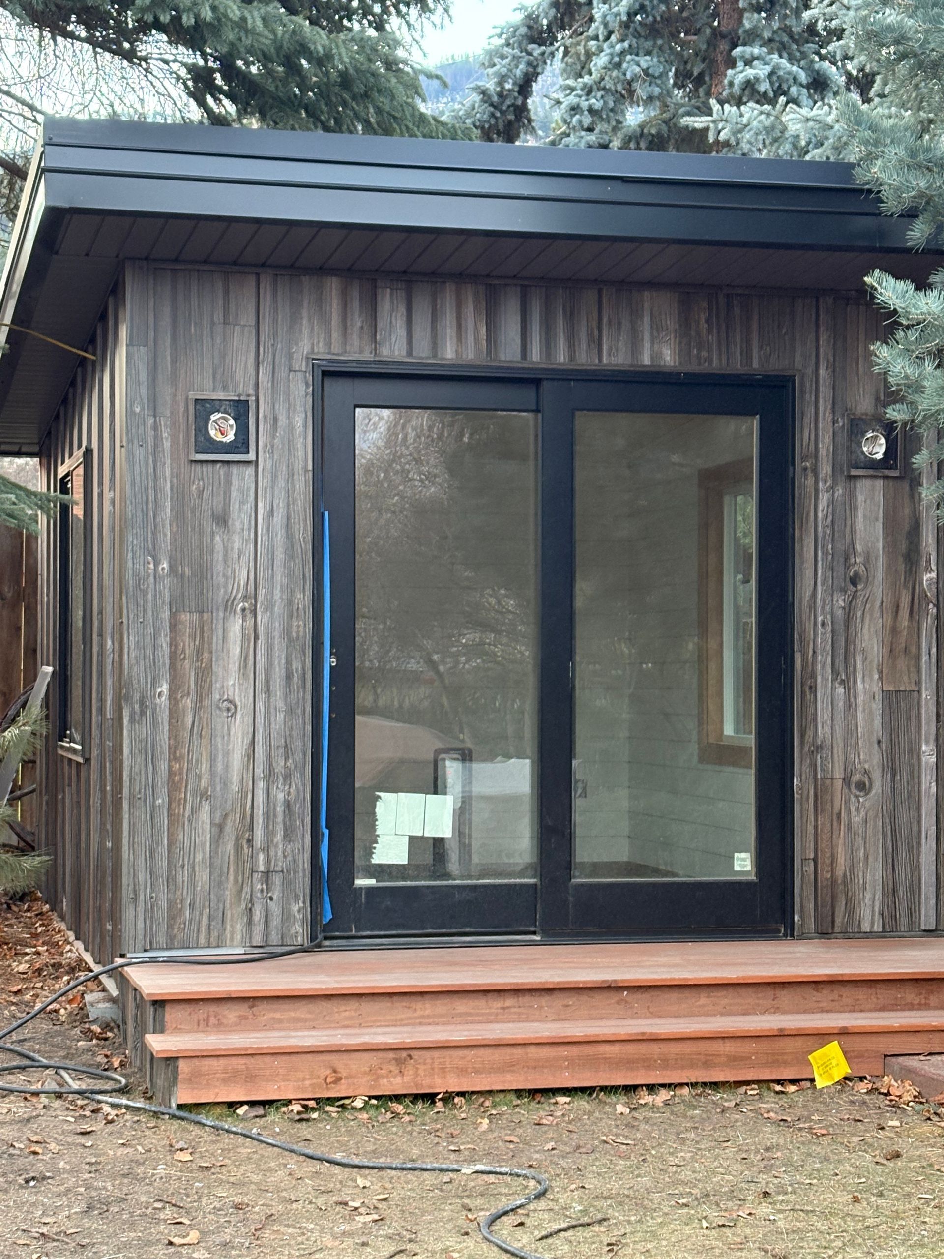 A small wooden house with sliding glass doors