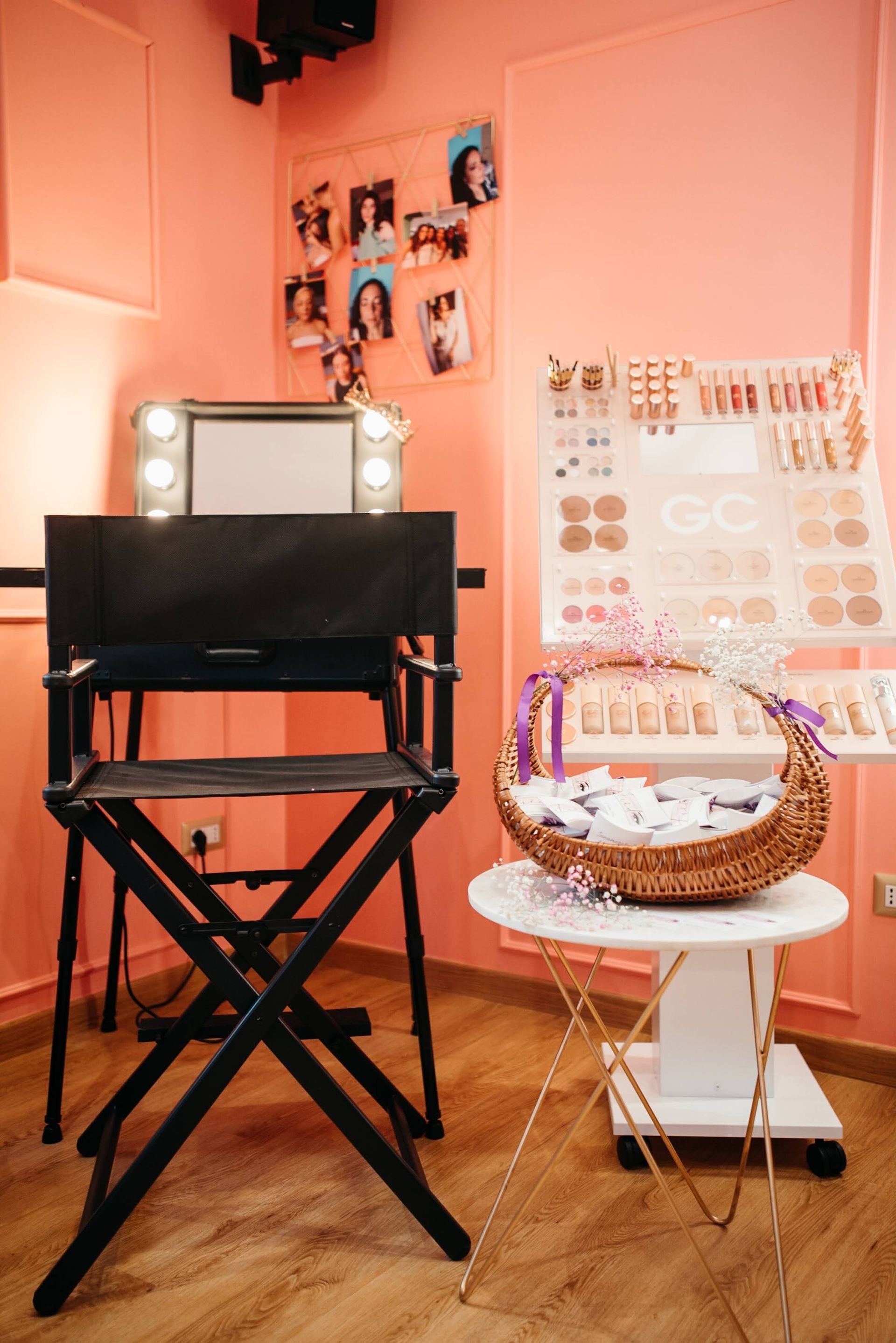 Interno di uno studio di trucco con sedia da regista, tavolo da trucco, esposizione di orecchini e un cesto di regali.