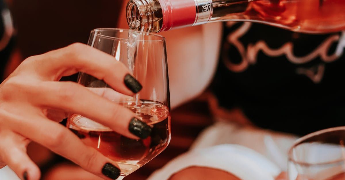 A woman is pouring wine into a glass.