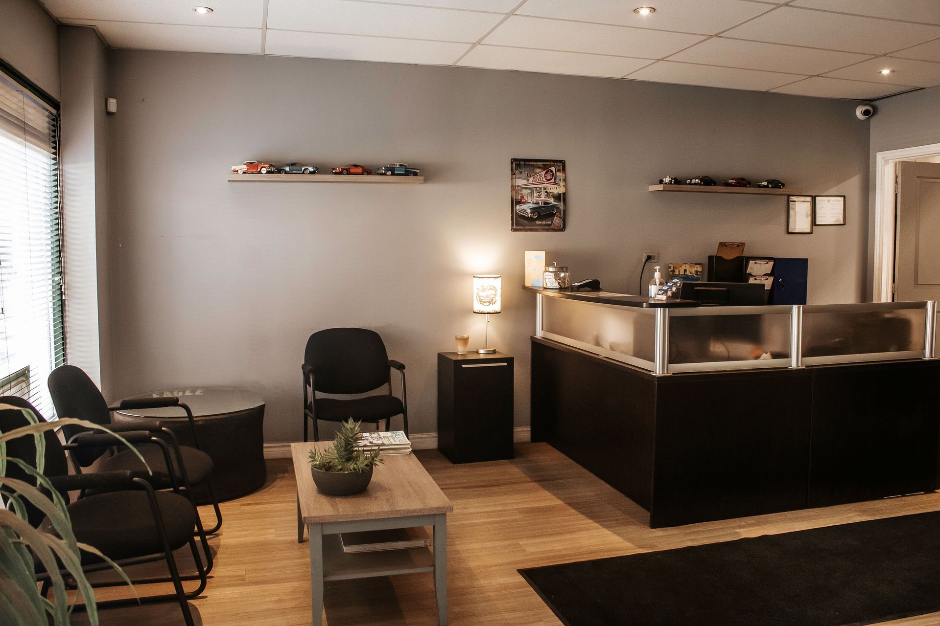 Waiting room with gray walls, chairs, and a reception desk.