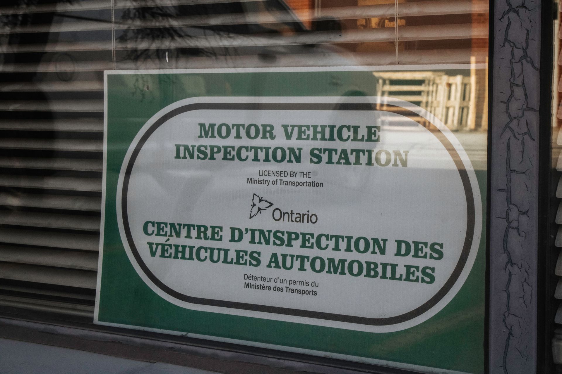 Sign in a window: Motor Vehicle Inspection Station, Ontario logo, green and white.