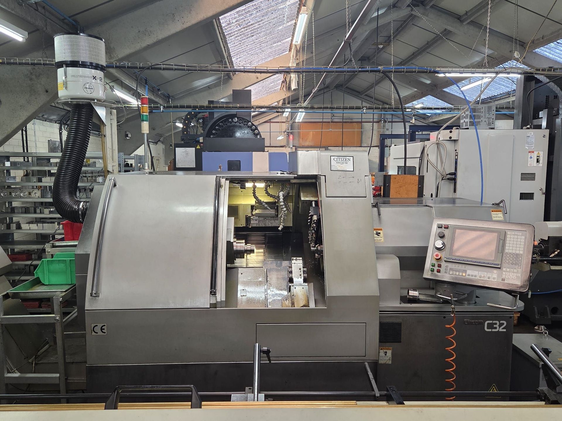 A machine is sitting in a warehouse next to a couch.