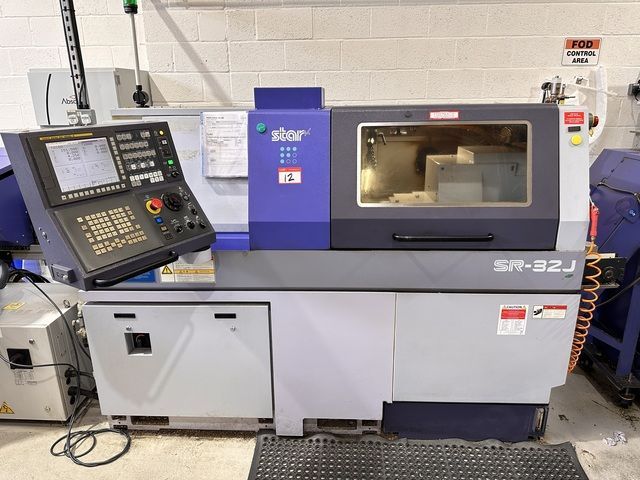 A large machine is sitting on the ground in a factory.