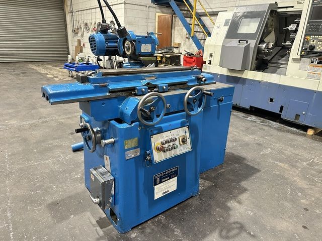 A large machine is sitting in a factory next to a green table.