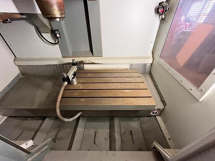 A machine is sitting on top of a wooden table in a room.