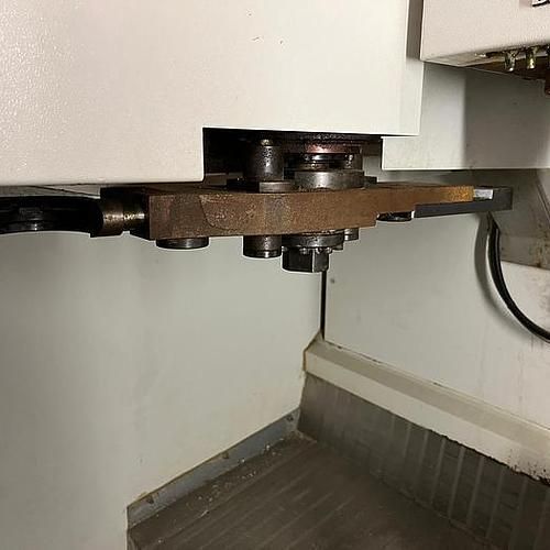 A machine is sitting in a corner of a room next to a wall.