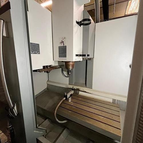 A machine is sitting on top of a wooden table in a room.