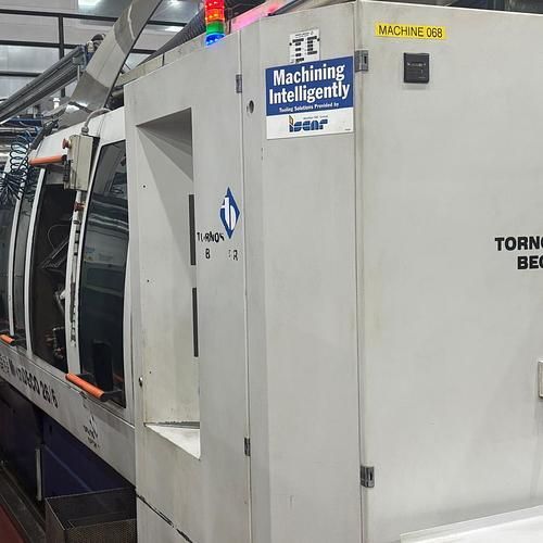 A machine with a sticker on it that says machining intelligently is in a factory.