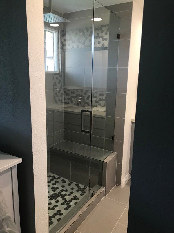 Bathroom Design — Bathroom with Clear Glass Door Black and White Small Tiles in La Habra, CA