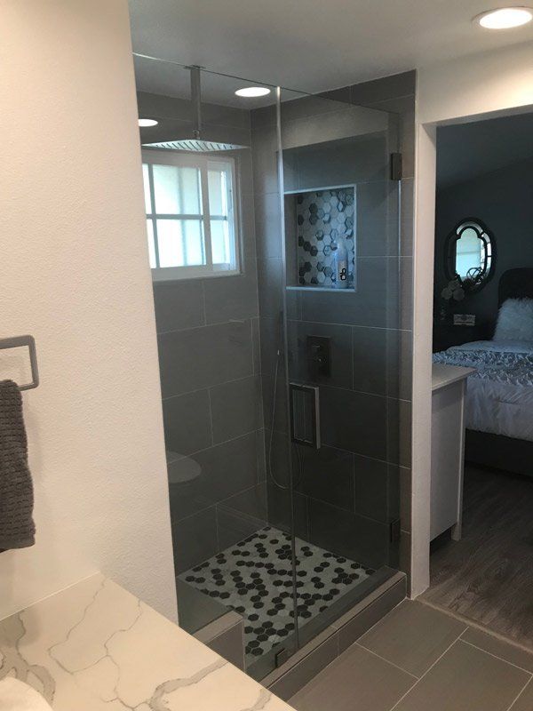 Bathroom Design — Bathroom with Clear Glass Door Beside Bedroom in La Habra, CA
