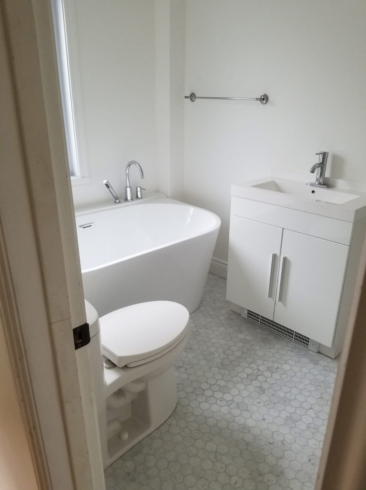 Une salle de bain avec baignoire, toilettes, lavabo et vanité.