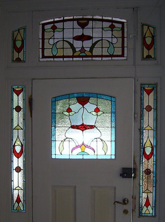 white door surrounded by red and blue leadlight