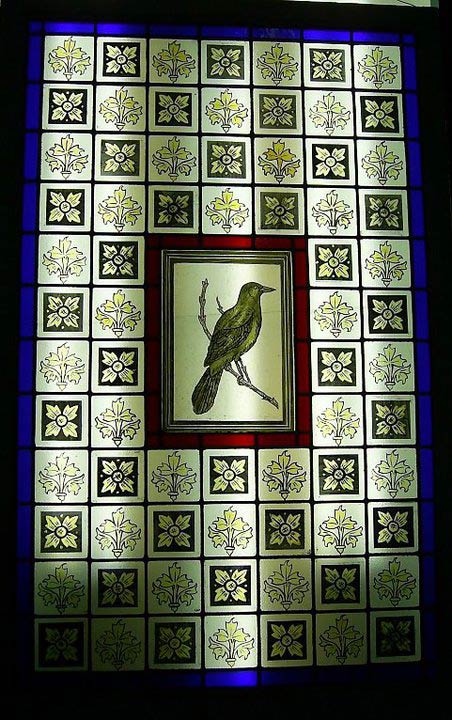 bird on branch surrounded by squares leadlight