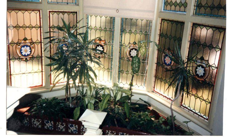 room with green plants and decorative leadlight windows