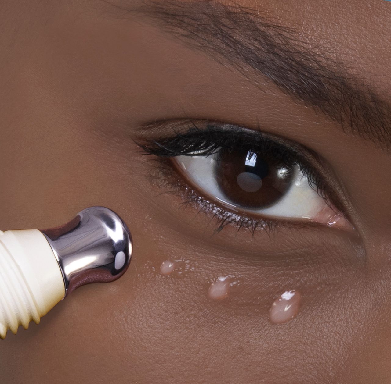 A woman is applying eye cream to her eye