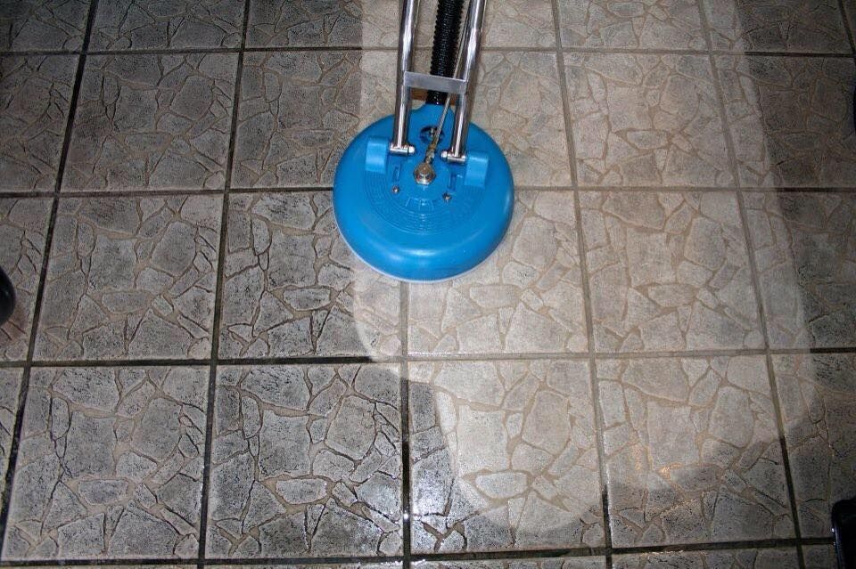 Blue floor cleaner scrubbing grey tiled floor — Ultimate Restoration Services in Koongal, QLD
