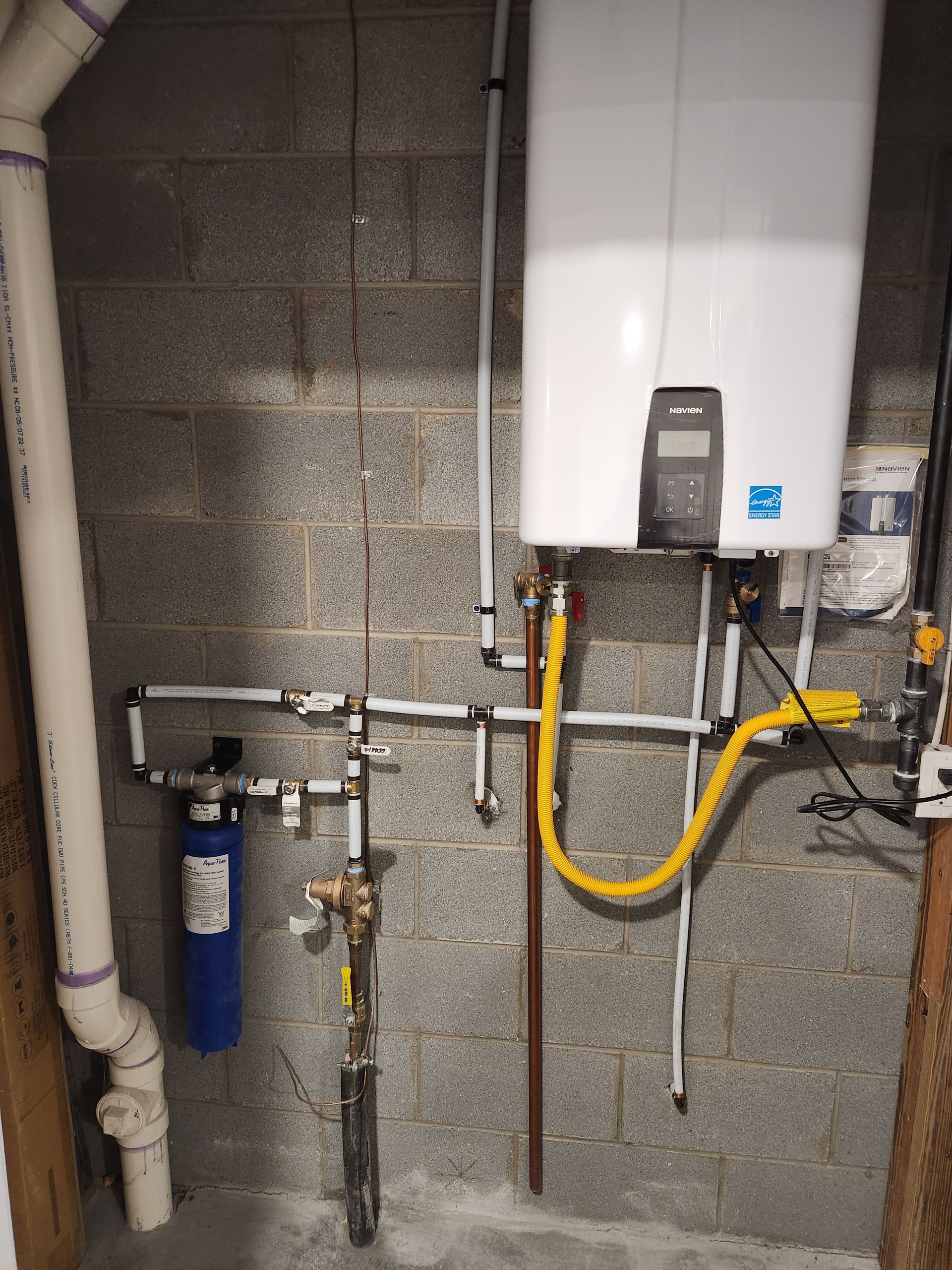 A water heater is connected to a gas line in a basement.